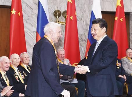 图为:习近平在莫斯科会见曾在中国东北抗日战场上和卫国战争中浴血奋战的18名俄罗斯老战士代表。